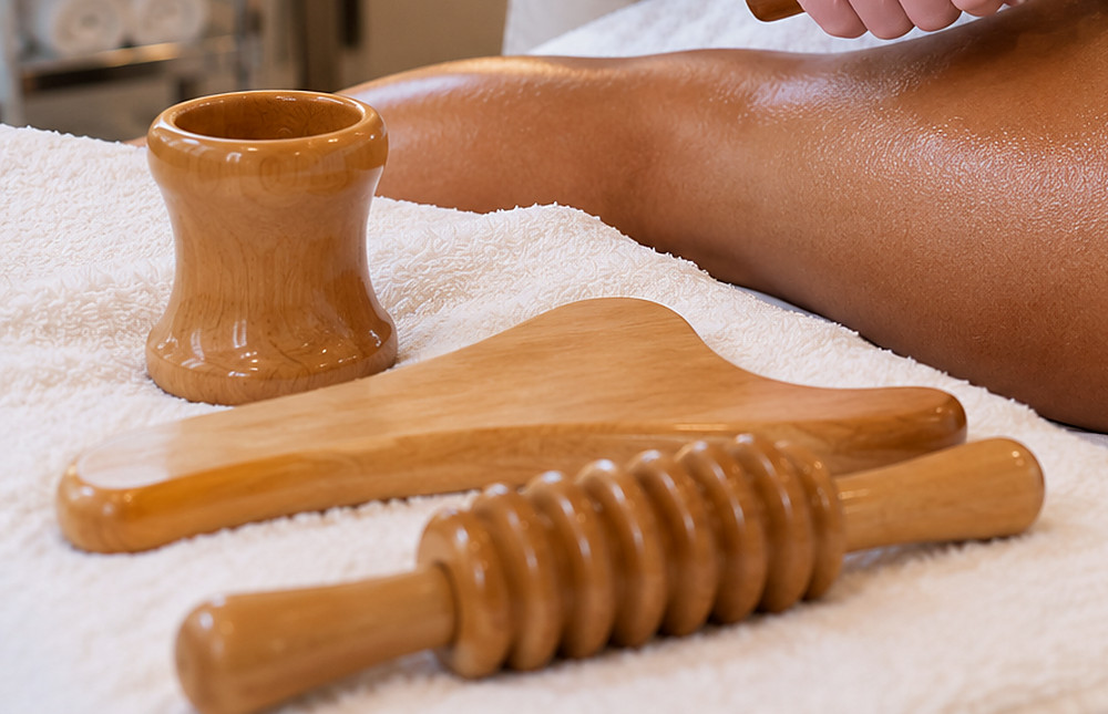Wood therapy tools including a wooden massage roller, Swedish cup and contour board at J Artistry Clinic Coventry